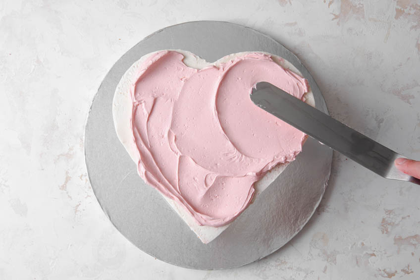 A heart-shaped cake covered in buttercream