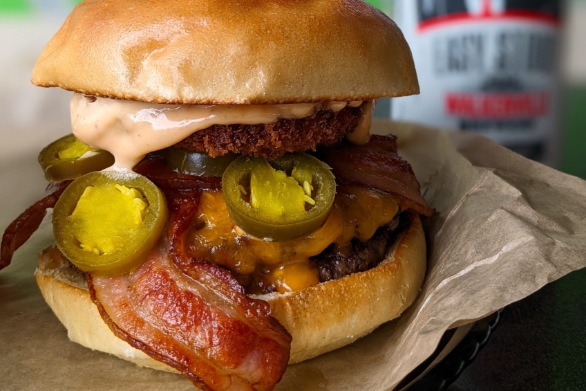 A burger with fried goat cheese, pickled jalapenos, hot pepper Colby cheese, bacon and chipotle mayo.