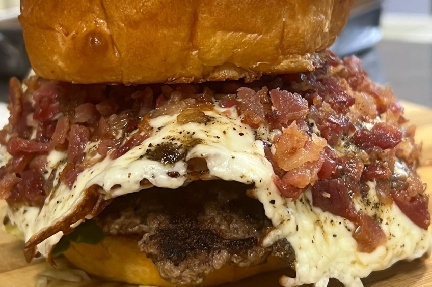 A burger made with hand-smashed beef, roasted garlic, cream cheese, fried mozzarella and candied bacon crumble.