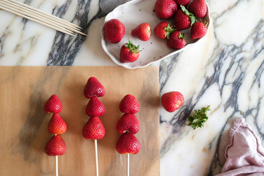 Skewered strawberries on parchment paper