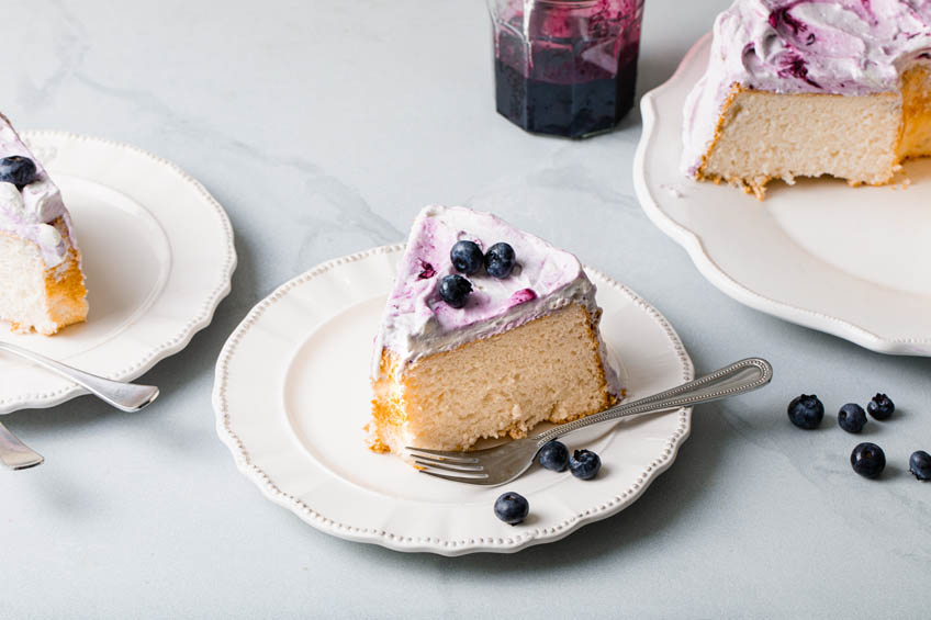 A slice of angel food cake with blueberry frosting