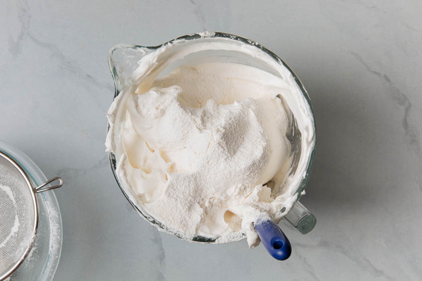 Flour sifted into a bowl of whipped egg whites