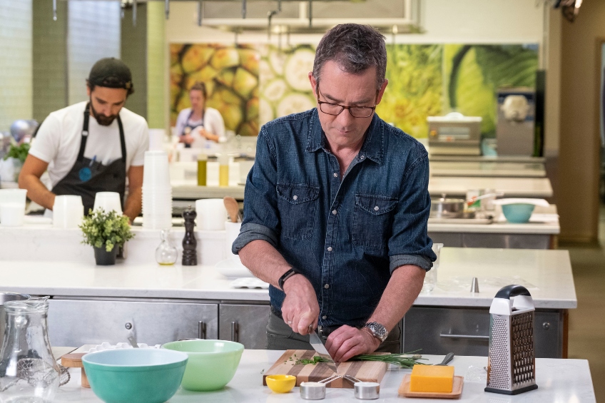 Ted Allen chopping green onion on the set of Chopped.