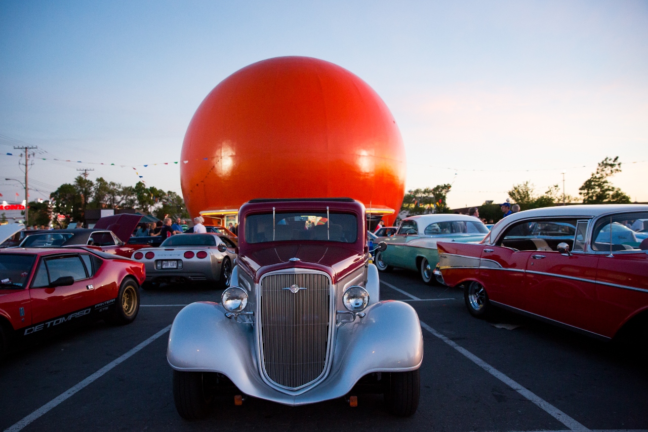 Gibeau's Orange Julep in Montreal, a large, orange-shaped drive-in restaurant with a silver vintage car parked in front.
