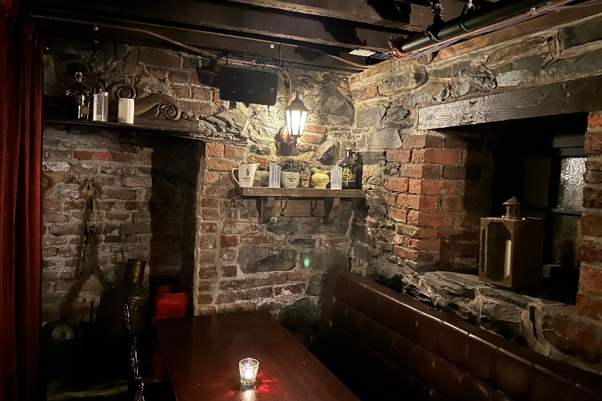 The Underbelly at YellowBelly Brewery in St. John's, Newfoundland, with restored brick walls from the 1800s and dark wood-topped tables.