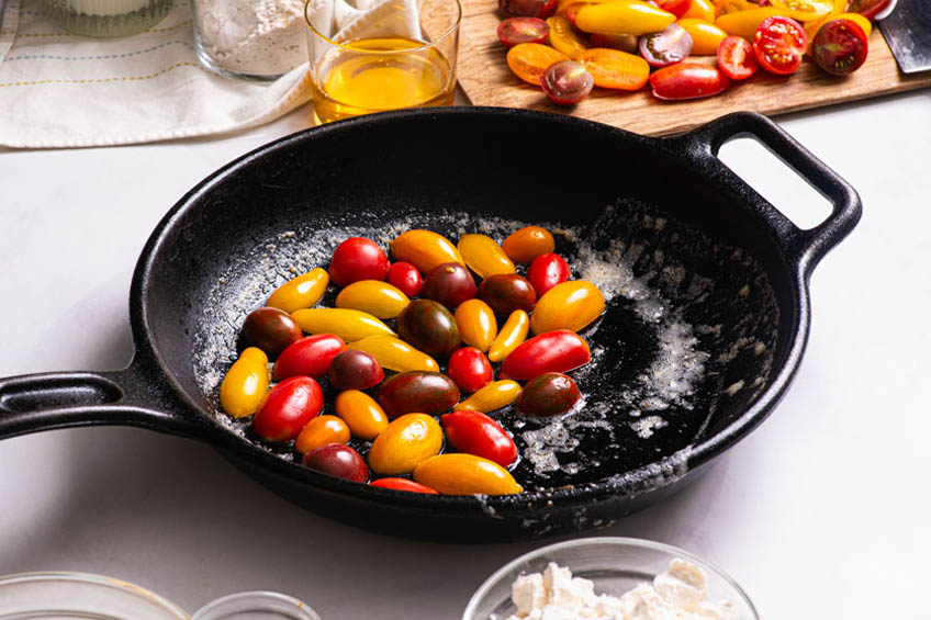 Sliced cherry tomatoes added to skillet