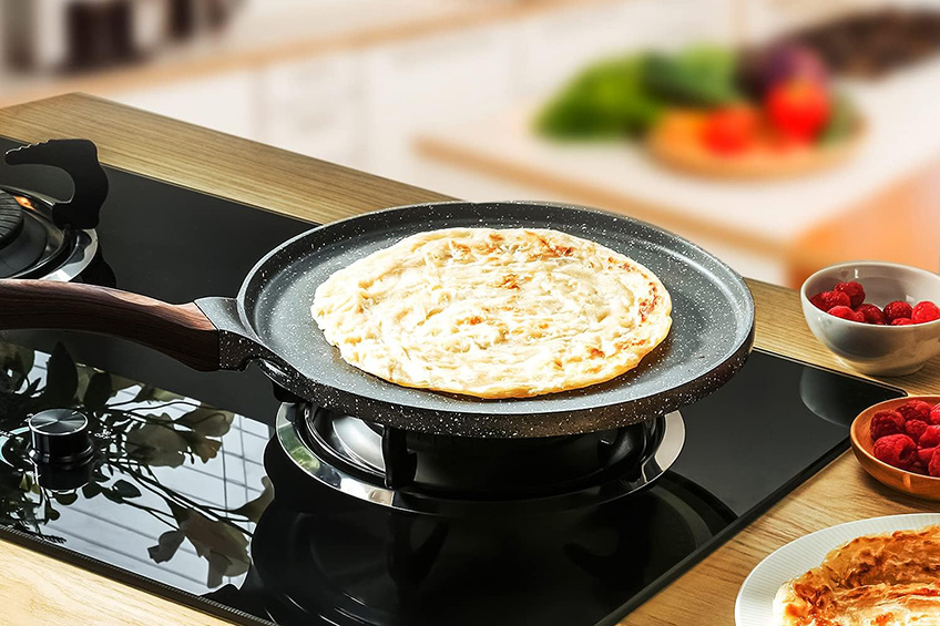 The Sensarte nonstick crape pan with a dosa on the stove.