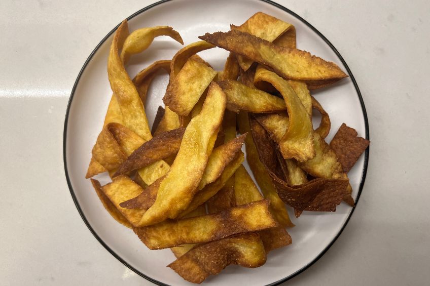 Homemade fried tortila chips on a round plate