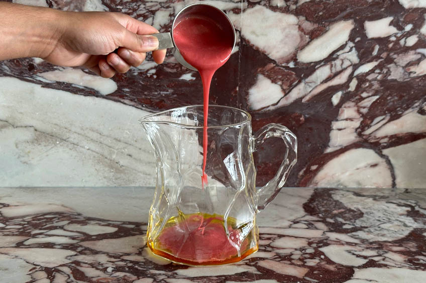 Raspberry puree being added to a pitcher