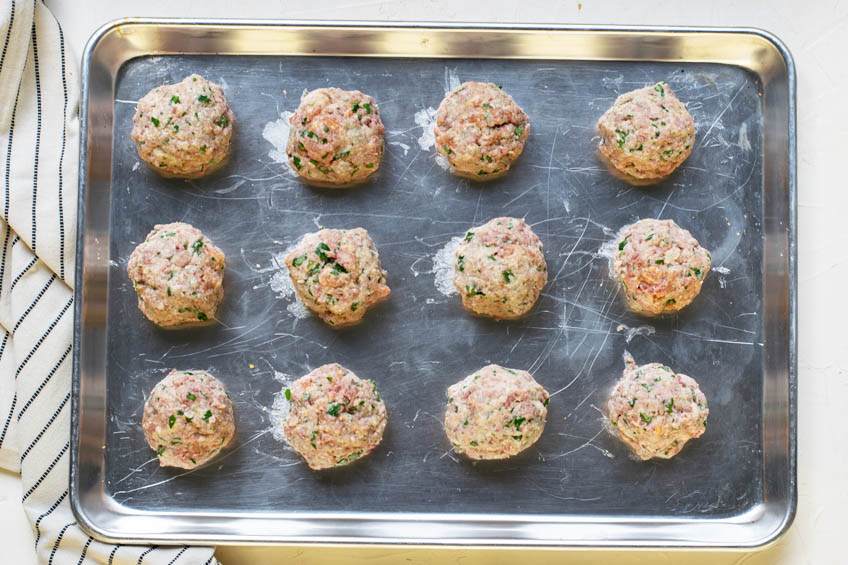 Uncooked meatballs on a sheet pan