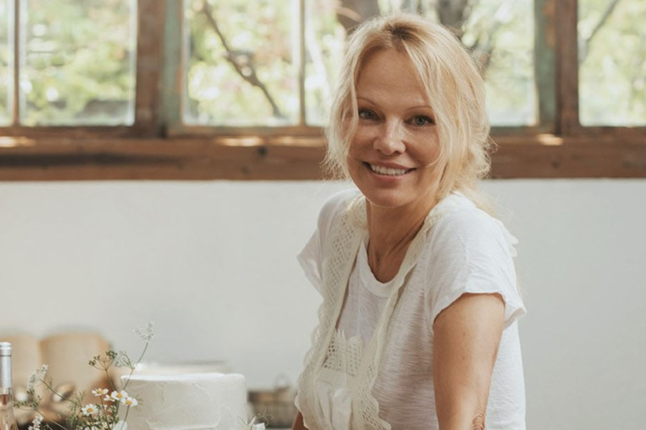 Pamela Anderson wears all white in a kitchen