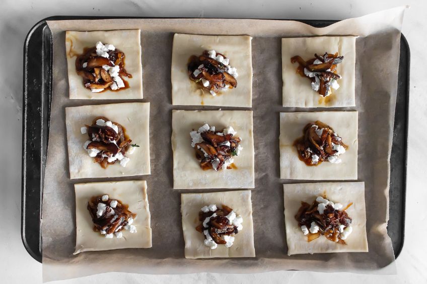 Unbaked Chevre and Mushroom Mini Tarts on a baking tray