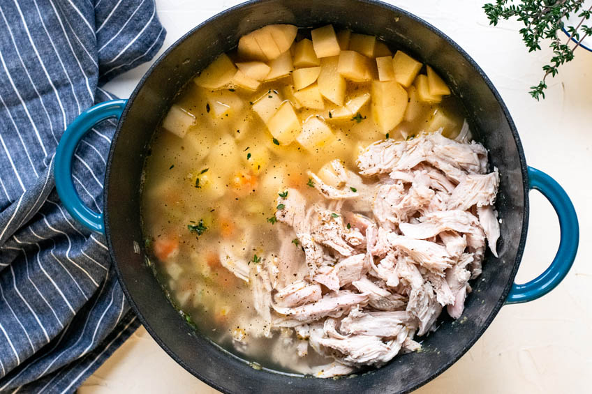 Broth, turkey and potatoes added to pot