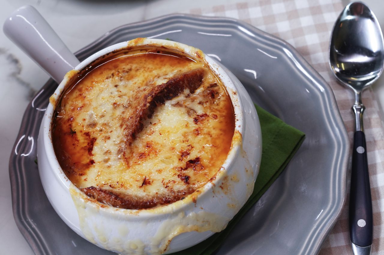 Cheesy French onion soup in a white ramakin