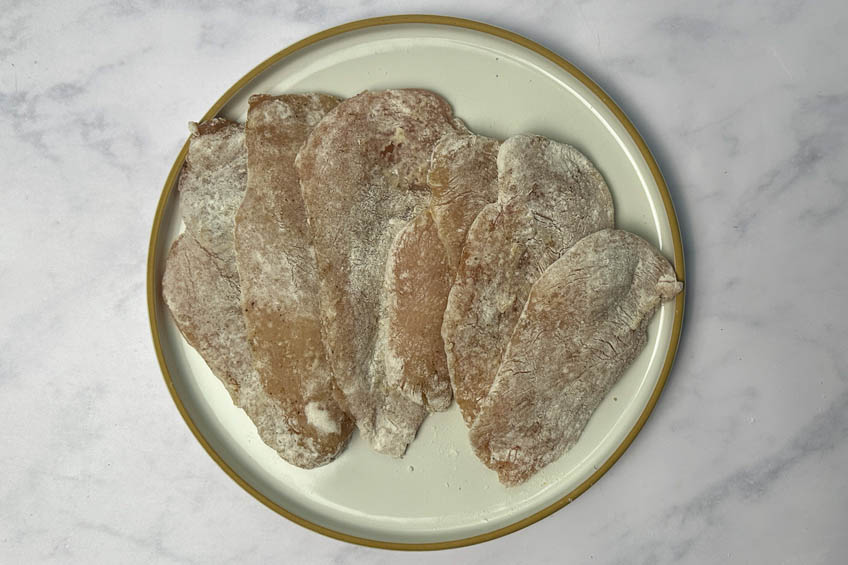 Dredged chicken breasts on a plate