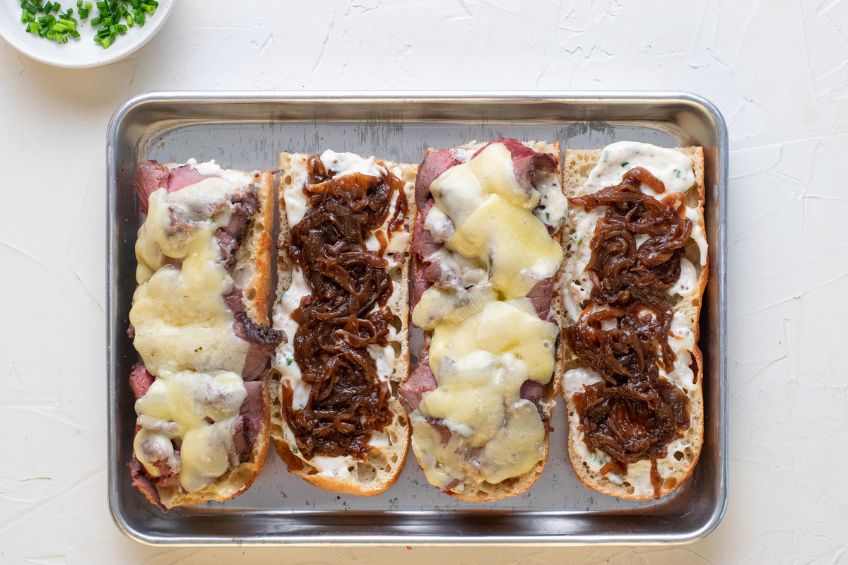 Sandwiches toasted and topped with melted gruyere