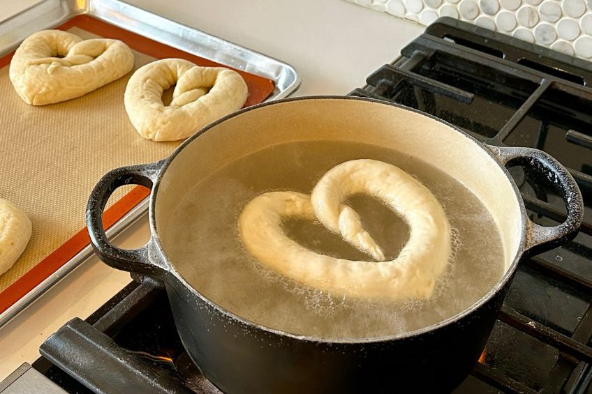 Heart pretzel boiling in water in a large pot