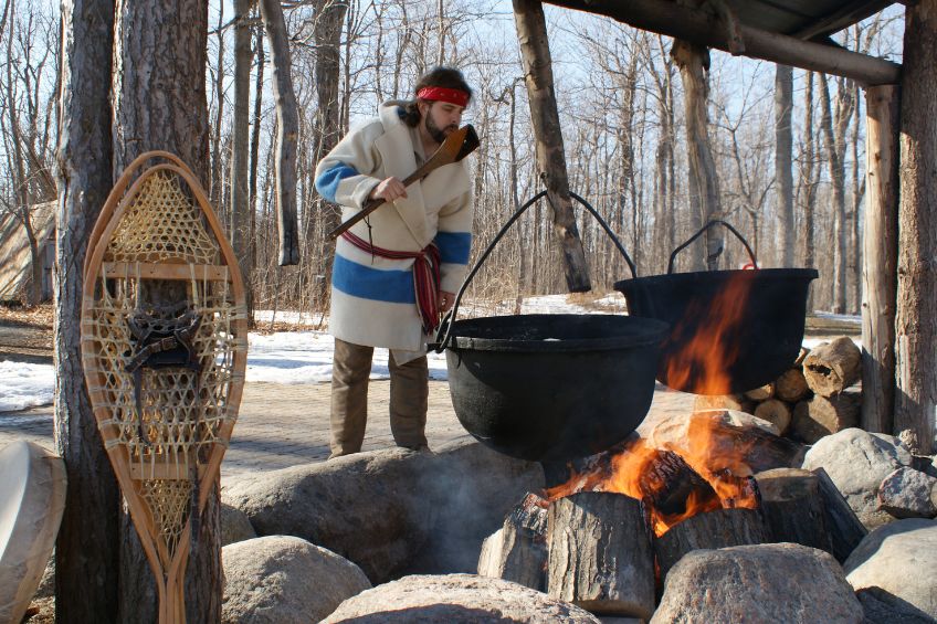 man boiling maple sap over fire