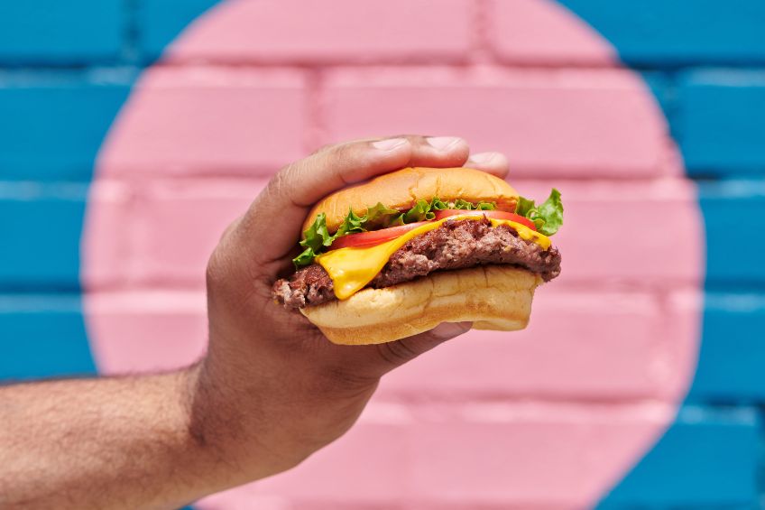 A person holding a burger