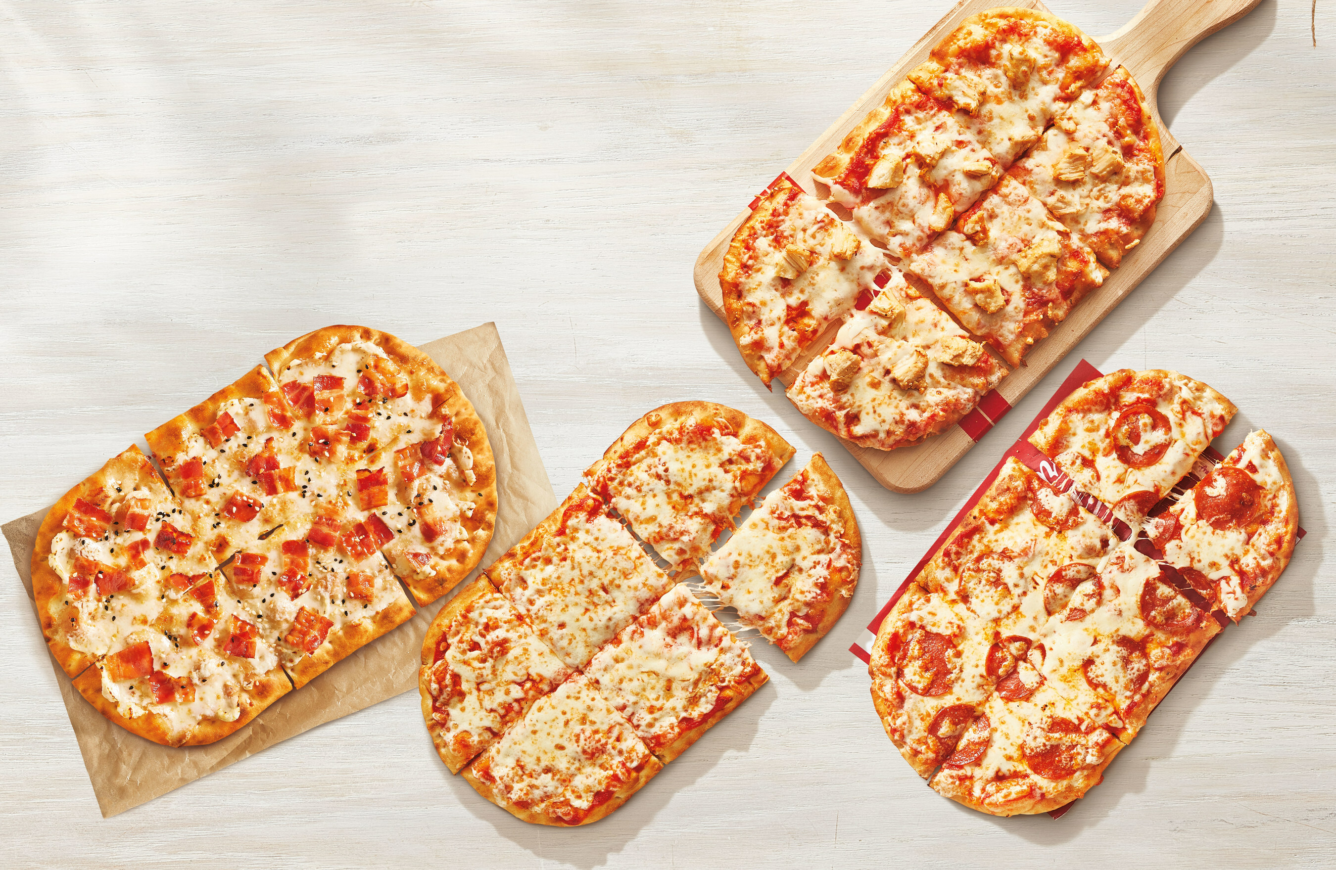 Four different Tim Hortons Flatbread Pizzas on a table.