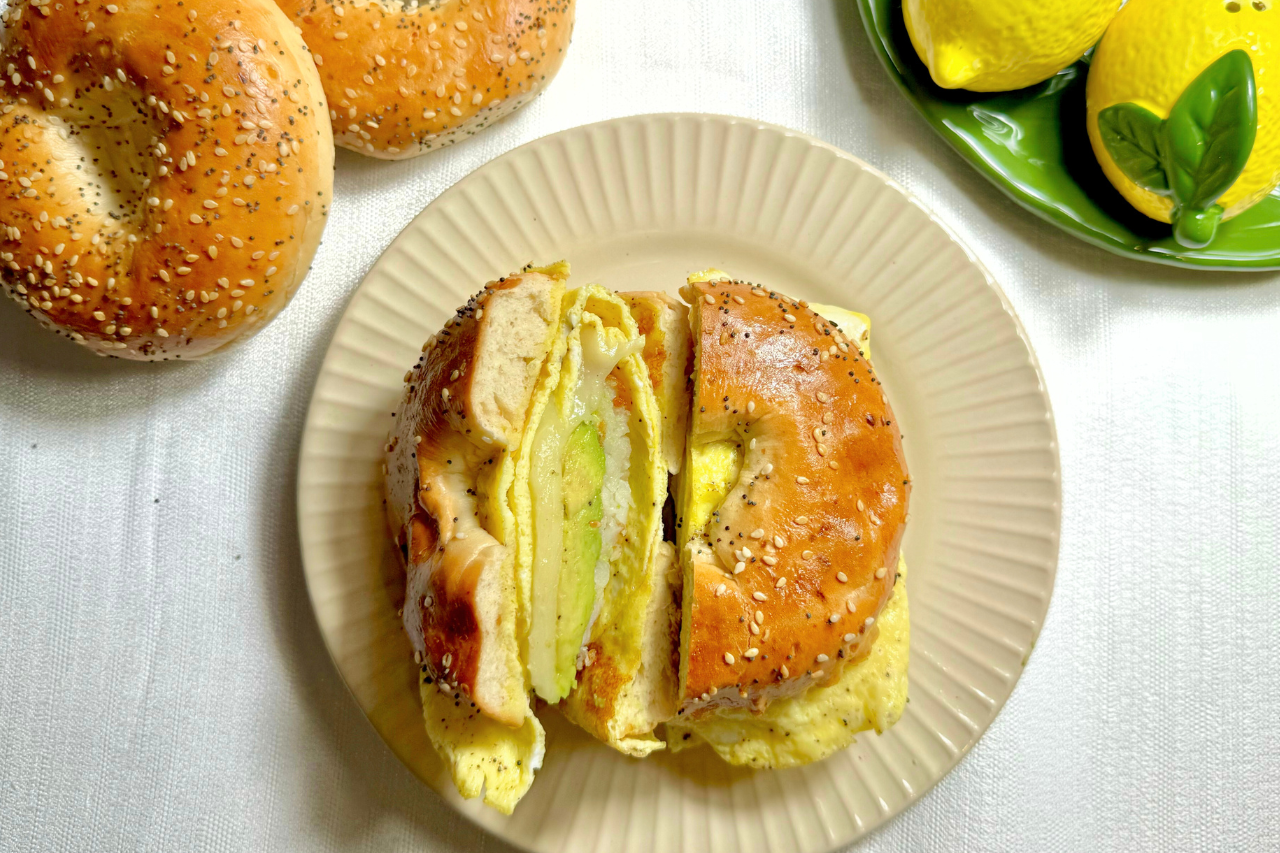 Bagel breakfast sandwich cut in half on a plate