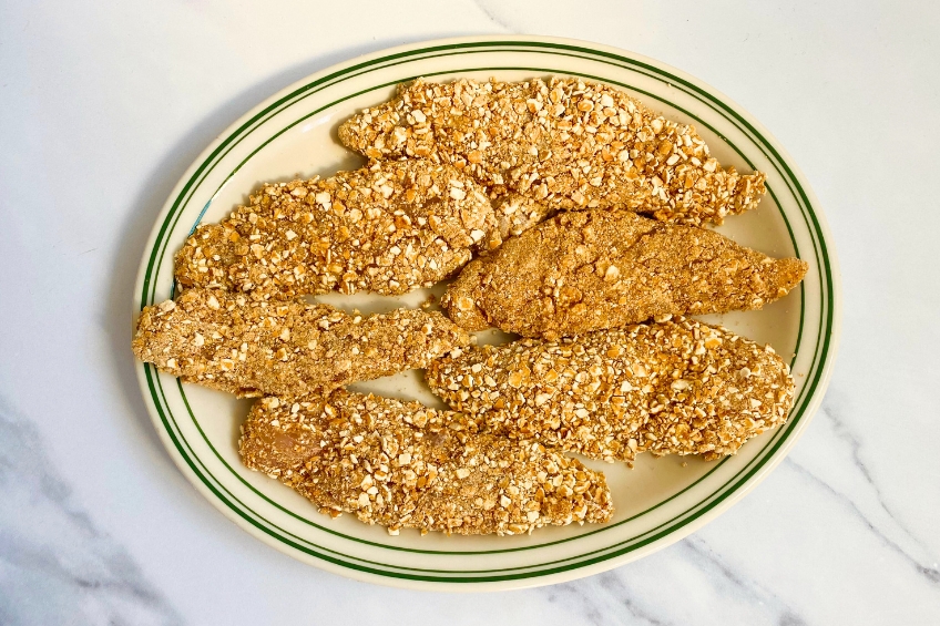 Raw pretzel-crusted chicken tenders on a plate