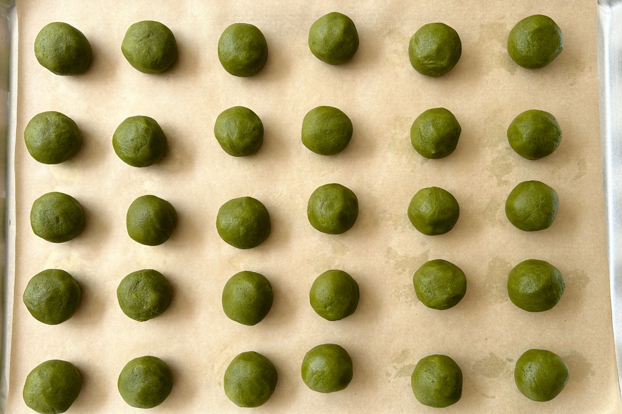 Matcha cookie balls on a baking tray.