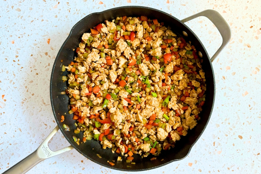 Chicken, sauce and scallion greens added to pan