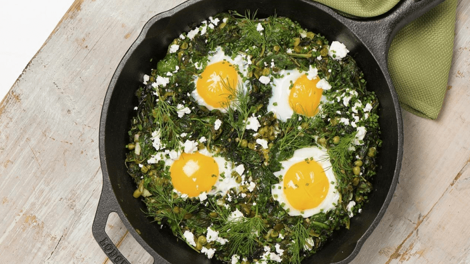 green shakshuka with eggs and feta cheese