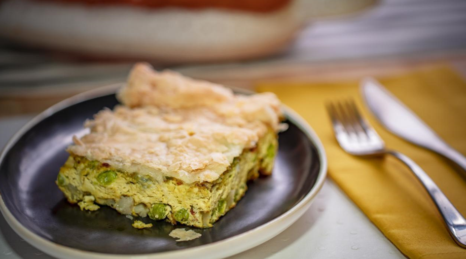 A frittata made with samosa inspired ingredients on a plate with a knife and fork