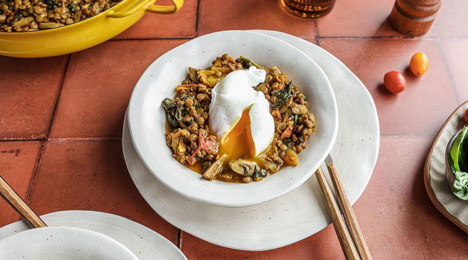 A bowl of stewed peas with a poached egg on top